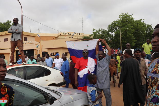 People, some carrying Russian flags, demonstrate in Niger's capital Niamey to show their support for the military rulers who seized power in a coup, on Aug. 3, 2023. 