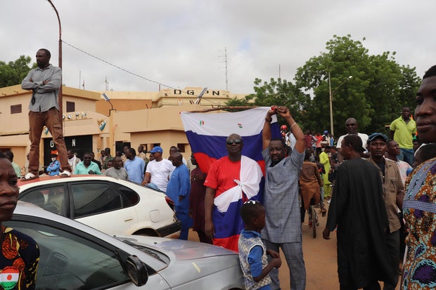 People, some carrying Russian flags, demonstrate in Niger's capital Niamey to show their support for the military rulers who seized power in a coup, on Aug. 3, 2023