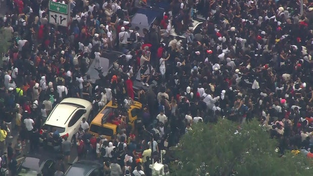 An aerial view of thousands of people crowded into Union Square. Multiple people stand on vehicles.