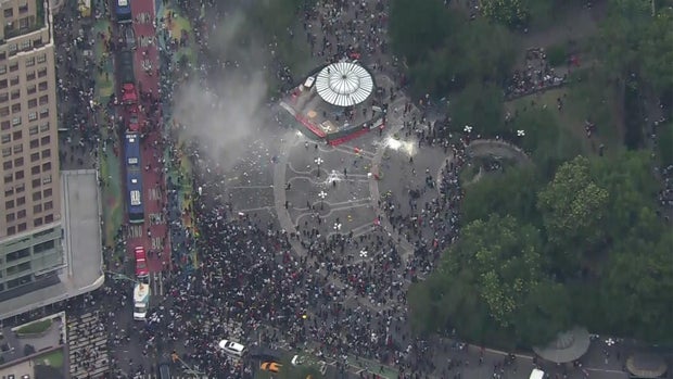 An aerial view of thousands of people crowded into Union Square. A cloud of smoke can be seen after someone set off a fire extinguisher.