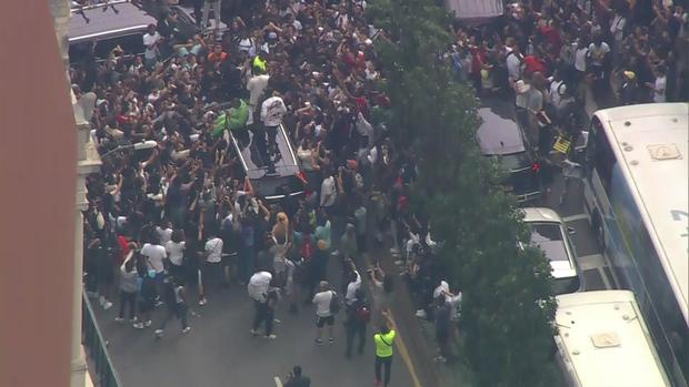 An aerial view of thousands of people crowded into Union Square. Some people stand on top of an SUV as passengers stick their heads out the moon roof. 