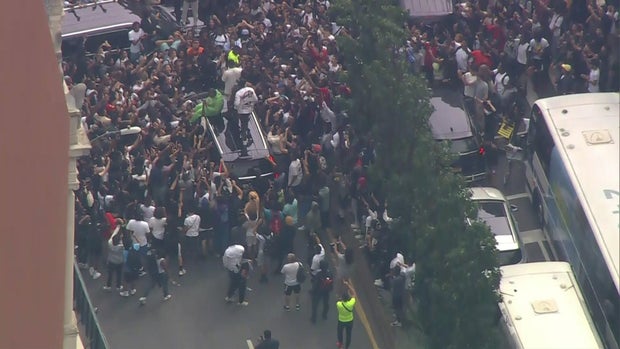 An aerial view of thousands of people crowded into Union Square. Some people stand on top of an SUV as passengers stick their heads out the moon roof.