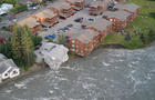 A drone view shows a house before it collapses into a river due to glacial floods in Juneau 