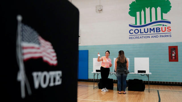 A volunteer helps voters cast their ballots during a special election for Issue 1 in Columbus, Ohio, on Aug. 8, 2023. 