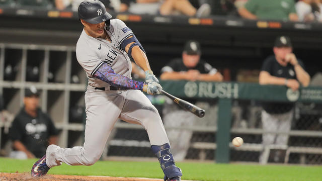 New York Yankees designated hitter Giancarlo Stanton (27) swings in acting hitting the ball and scoring New York Yankees right fielder Aaron Judge (99) during a Major League Baseball game between the New York Yankees and the Chicago White Sox on August 9, 