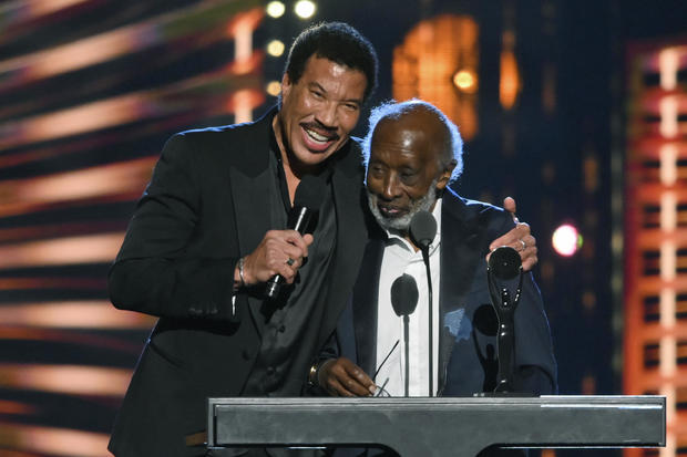 Lionel Ritchie, left, hugs Clarence Avant during the Rock and Roll Hall of Fame induction ceremony Oct. 30, 2021, in Cleveland. 