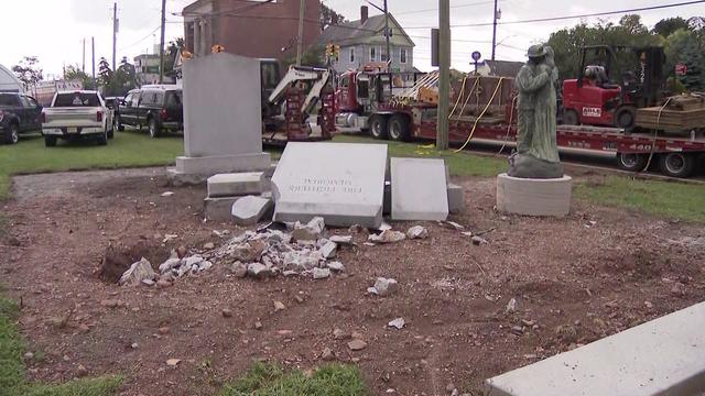 Stone monuments in a firefighter memorial lay on the ground. 