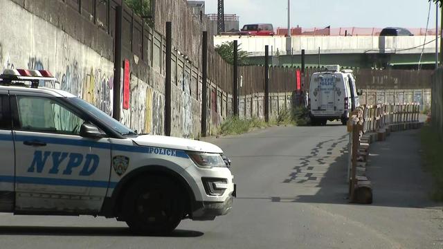 An NYPD vehicle blocks off a street in the Bronx with a Crime Scene Unit vehicle in the background. 