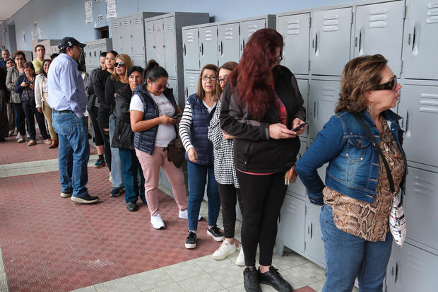 Voters wait in line to cast a ballot at a polling station during the presidential elections in Quito, Ecuador, on Sunday, Aug. 20, 2023. 