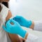 Doctor applies bandage to preteen girl's arm following an immunization 