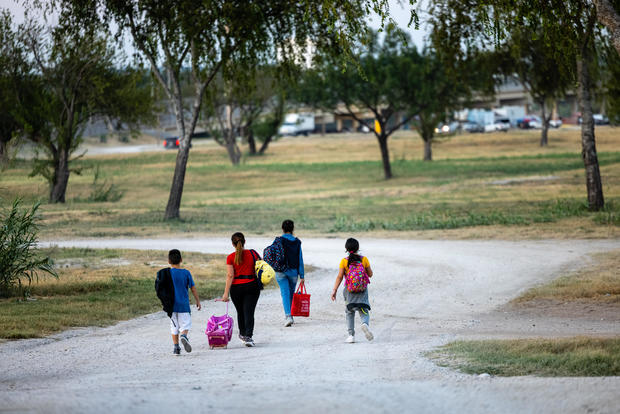 A family from Venezuela walks into the migrant camp under the international bridge on Sept. 18, 2021, in Del Rio, Texas.  