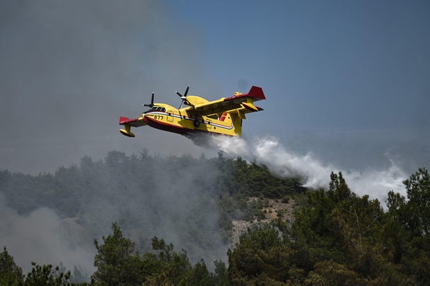 A Canadair amphibious aircraft, drops water over wildfires spreading in Dadia forest, one of the most important areas in Europe for birds of prey, as it rages in Dadia, near Alexandroupoli, north Greece, on August 24, 2023. Hundreds of firefighters in Greece struggled Thursday to tame major wildfires burning for a sixth day, leaving 20 dead and prompting growing outrage among stricken residents