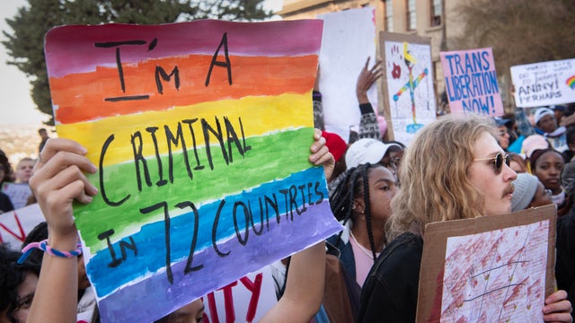 Protesters wave placards while joining supporters of the LBTQ community as they stage a protest at the University of Cape Town on July 24, 2023. 