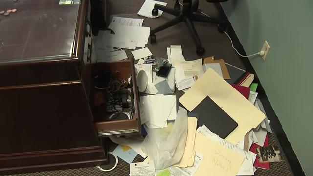 Papers, folders and other office items are strewn on the floor of an office inside Generations Church. 
