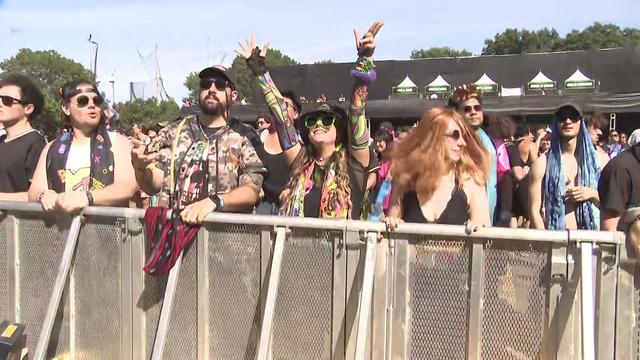 A crowd of concertgoers stands up against a fence in front of the stage at the Electric Zoo Festival. 