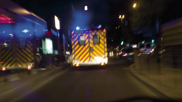 Ambulance driving on street at night 