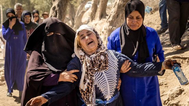 A woman is helped as she reacts to the death of relatives in an earthquake in the mountain village of Tafeghaghte, southwest of Marrakech, on September 10, 2023. 