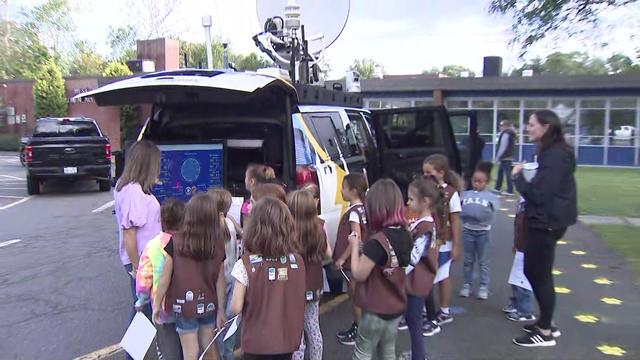 Vanessa Murdock stands with a group of Girl Scouts at the Mobile Weather Lab. 