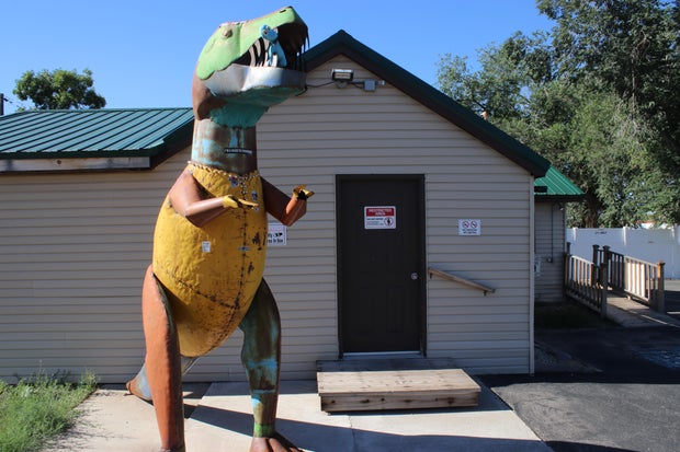 A dinosaur sculpture outside of DinoTreats pot store in Colorado