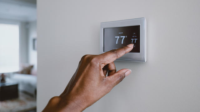 Woman Adjusts Thermostat 