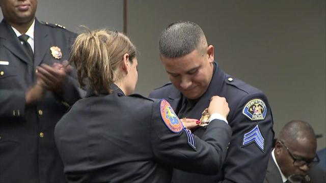 Nassau County Police Sgt. Lilly Perez pins a sergeant's shield on the uniform of her husband, Hempstead Village Police Sgt. Mark Perez. 