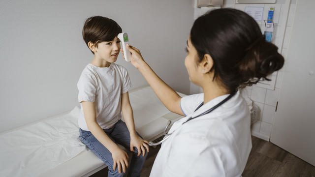 Nurse taking a boy's temperature 