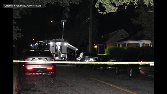 Crime scene tape blocks off a residential street in New Milford at night. 