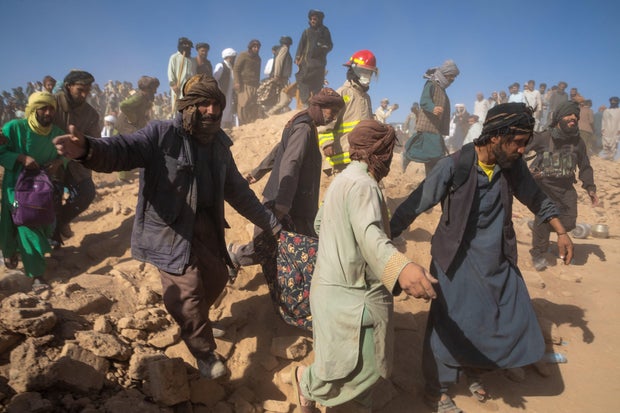 Afghans gather the remains of earthquake victims from destroyed houses after a massive 6.3 magnitude earthquake hit the western Herat region, in Herat city, Afghanistan