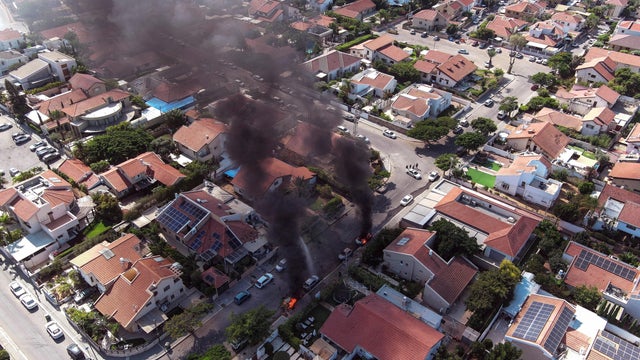 An aerial view shows vehicles on fire during a rocket attack from the Gaza Strip, in Ashkelon, southern Israel, October 7, 2023. 