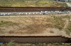 Aerial view of migrants waiting to be processed between border wall fences on the United States side of the U.S.-Mexico border, seen from Tijuana, Baja California state, Mexico, on May 11, 2023. 