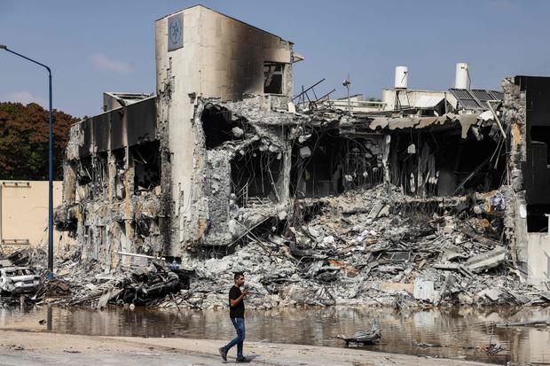A man walks past an Israeli police station in Sderot after it was damaged during battles to dislodge Hamas militants who were stationed inside, on October 8, 2023. 