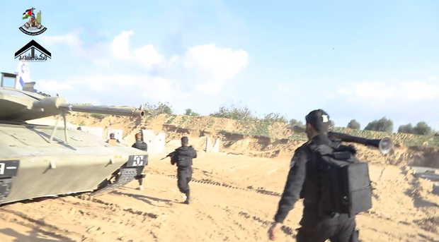 Hamas militants run past a mock Israeli Merkava tank in a propaganda video from December