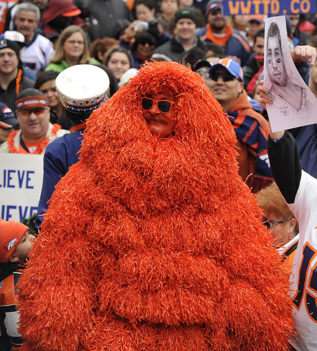 Denver Bronco fan Kerry Green, dressed as the Mile High Monster in over 500 pom pomes, and Candy Lewis, holding a drawing of Tim Tebow, joined over 300 fans, Friday, January 13, 2012, during a Denver Broncos Spirit Rally on Bannock Street in front of the