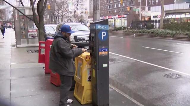 A man pays at a New York City parking meter. 