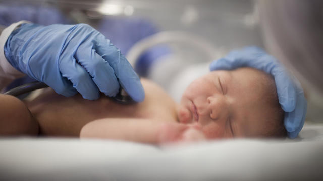 USA, Utah, Payson, Nurse listening to heartbeat of newborn in incubator 