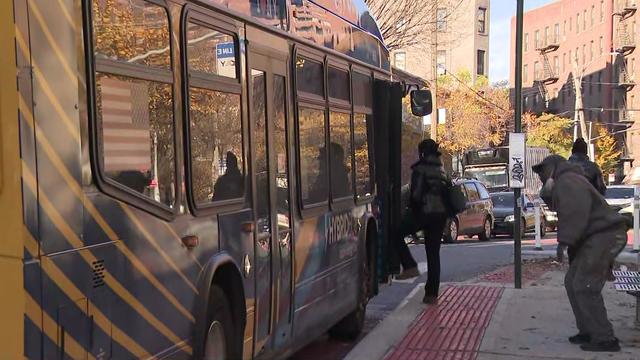 Individuals board a bus in the Bronx. 