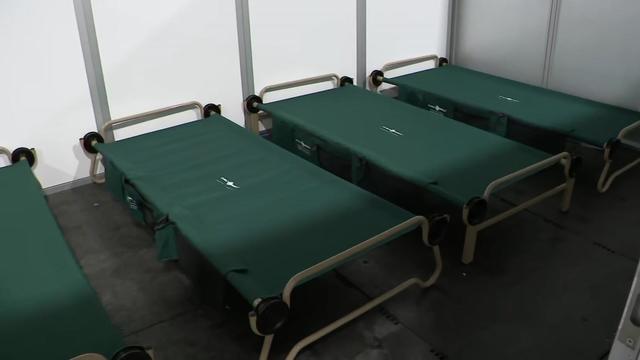 Four cots close next to each other in a small room in the asylum seeker shelter at Floyd Bennett Field. 