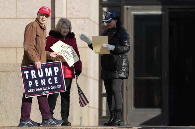 Trump supporters hold signs outside the Minnesota Judicial Center, Thursday, Nov. 2, 2023, in St. Paul, Minnesota. 