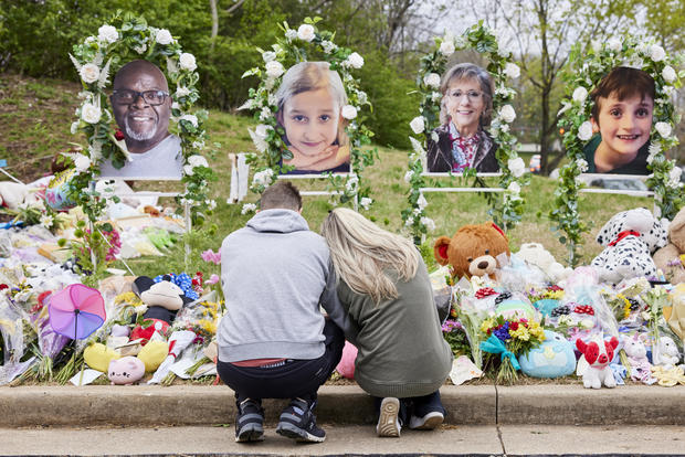A couple prays at the memorial for the Covenant School shooting victims at the Covenant School, March 31, 2023, in Nashville, Tennessee. 