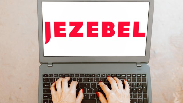 The Jezebel logo displayed on a laptop 