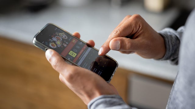 Close-up on a man betting online on a sports app in his cell phone