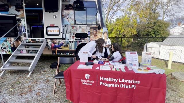 An individual gets a blood pressure screening outside a mobile health unit in Southold. 