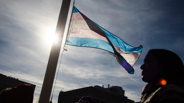 People attend a ceremony at Queens Park for Trans day of remembrance.