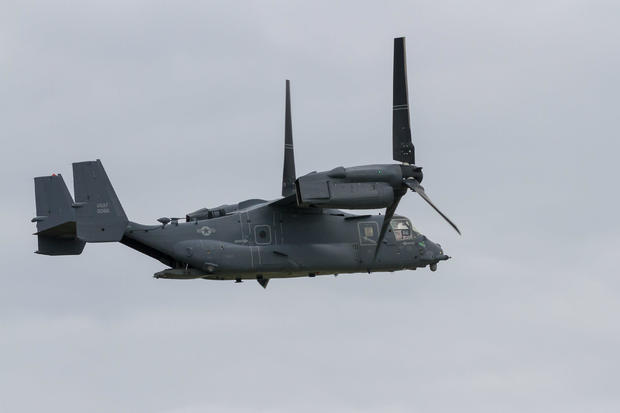 A USAF Bell Boeing V22 Osprey flying in front of the air- 