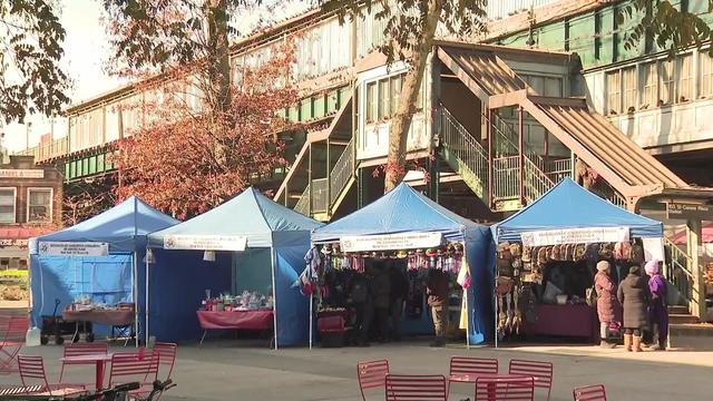 Four blue tent booths set up in Corona Plaza. 