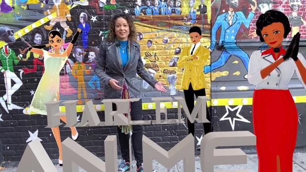 CBS New York's Jessi Mitchell stands in front of the Planet Harlem mural. Using augmented reality, animated characters representing Josephine Baker, Adam Clayton Powell and Zora Neale Hurston stand next to her, along with the words "Harlem Anime." 
