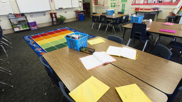 Empty desks with papers in classroom 