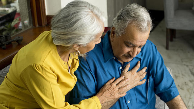 Wife comforting her husband suffering with severe chest pain 