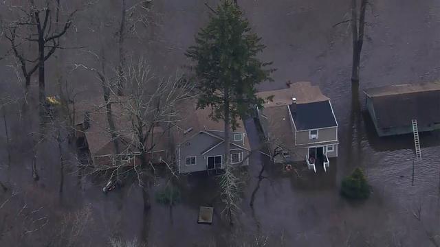 An aerial view of Little Falls shows homes surrounded by flood waters. 
