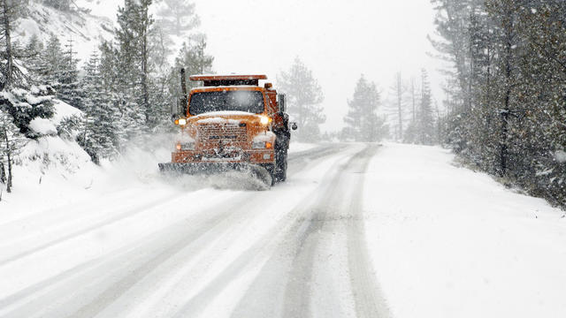 Snow plow clearing a road of snow and ice 